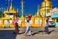 People walking on street next to a Yangon Myanmar pagoda and stupas Royalty Free Stock Photo