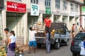 Yangon, Myanmar - Feb 13, 2018: Burmese workers move coconuts from a light truck into a store