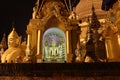 Night shot of stucco buddha statue decorated in golden be enshrined inside the arch at Shwedagon Pagoda, Yangon Myanmar