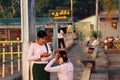 Two Myanmarese woman in tradition dress, one person checking the mobile phone and another hair styling with flowers in Yangon