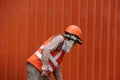 The man are working construction with orange color of safety helmet and safety vest on orange wall background. Royalty Free Stock Photo