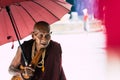 Yangon, Myanmar - March 2019: old Buddhist monk with red umbrella walks in Shwedagon pagoda