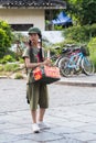 Yangshuo, China - circa July 2015: Chinese young pioneer girl sells food or souvenirs on the streets of tourist town Yangshuo on t