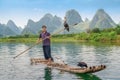 Cormorant fisherman and his birds on the Li River in Yangshuo, Guangxi, China