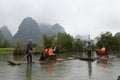 Men rowing tourists on Bamboo Rafts on Yulong River, China