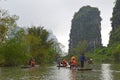 Men rowing tourists on Bamboo Rafts through the Karst landscape on Yulong River, China