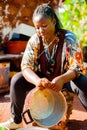 Yaounde, Cameroon - 10 august 2018: young healthy and serious african woman doing house chores outdoor washing dishes in sunny day