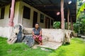 Local Micronesian native women sitting on on the porch of an authentic local house, with three stone money rai. Yap island, FSM.