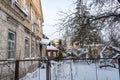 Yard area covered with snow after a snow storm. Winter city landscape. Icicles hang from the roof of an old brick building Royalty Free Stock Photo