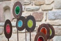 Yard with colorful metal decorations with a brick wall in the background