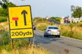 200 yards roadworks warning sign on UK motorway at evening with traffic passing Royalty Free Stock Photo