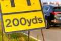 200 yards roadworks warning sign on UK motorway at evening with traffic passing Royalty Free Stock Photo