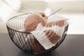 Yarn balls and knitting needles in metal basket on grey table against blurred background. Creative hobby Royalty Free Stock Photo