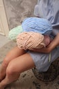 Yarn close-up in the hands of a young unrecognizable girl. A young woman in a blue dress with skeins of thread in her