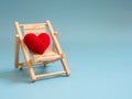 Yarn red heart on the wooden beach chair on blue screen background isolated. copy space for text. Valentines day, love concept a Royalty Free Stock Photo
