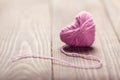 Yarn of wool in heart shape symbol on wooden Royalty Free Stock Photo