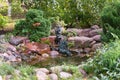 Fountain in the park - a little boy plays the flute on the shore of the pond