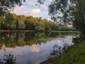 Yaroslavl. Warm evening in Neftyanik Park. Park refinery. Reflection of colorful sunset in the lake. Peace and quiet surrounded by Royalty Free Stock Photo