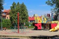 Yaslo, Poland - july 12 2018: Children`s playground in the park amidst greenery. Multicolored swings and buildings for children fr