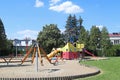 Yaslo, Poland - july 12 2018: Children`s playground in the park amidst greenery. Multicolored swings and buildings for children fr