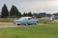 Yaslo, Poland - july 3 2018: Old American classical cadillac of blue color drives throuth a green. Back`s headlight with bumper an Royalty Free Stock Photo