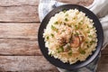 Yassa chicken with onions and garnished with couscous closeup. h