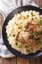 Yassa chicken stewed with marinated onions and couscous closeup.