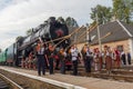 Yasynya, Ukraine - September 29, 2016: Musicians in national dress posing against the backdrop of the old steam locomotive