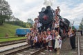 Yasynya, Ukraine - September 29, 2016: Musicians in national dress posing against the backdrop of the old steam locomotive