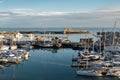 Yatchs moored in Ramsgate Royal Harbour. The harbour lock gates, the end of pier restaurant and lighthouse can also be seen