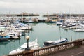 Yatchs moored in Ramsgate Royal Harbour. The harbour lock gates, the end of pier restaurant and lighthouse can also be seen