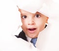 Yawning kid looks through a hole in white paper Royalty Free Stock Photo