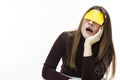 Yawning Lazy Caucasian Woman in Burgundy Turtleneck Sweater With Yellow Sticky Note on Her Forehead. Against White Background