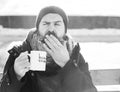 Yawning man drinks from cup on snowy winter day outdoors on natural background