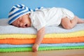 Yawning sleeping baby on colorful towels stack Royalty Free Stock Photo