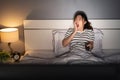 Yawning sleepy woman man watching TV movie on bed at night Royalty Free Stock Photo