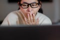 Yawning and sleepy woman working on laptop in office at home. Tired businesswoman wearing eyeglasses using laptop sitting in Royalty Free Stock Photo