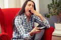 Yawning woman holding tv remote control Royalty Free Stock Photo