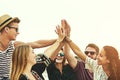 Yay us. a happy group of friends high fiving on the beach.