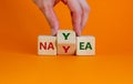 Yea or nay symbol. Businessman turns a cube changes the word 'nay' to 'yea'.