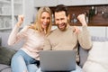 Yeah. Cheerful guy got a promotion at work, won the lottery, bought a vacation ticket, sitting at laptop. Caucasian Royalty Free Stock Photo