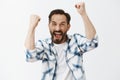 Yeah come on we will win. Portrait of happy joyful and emotive mature european guy with beard and dark hair, raising