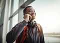 Yeah, I actually just landed. a handsome young man making a call while standing in an airport. Royalty Free Stock Photo