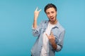 Yeah, that`s crazy! Portrait of enthusiastic man in worker denim shirt showing rock and roll hand gesture Royalty Free Stock Photo