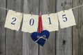 Year 2015 on antique paper with red and blue heart hanging on clothesline by shabby wood fence Royalty Free Stock Photo