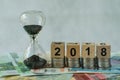 Year 2018 business time countdown or long term investment concept as hourglass or sandglass on pile of Euro banknotes with wooden Royalty Free Stock Photo