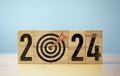 2024 year with dartboard and arrow on wooden block cube for setup new business objective target and goal since new year concept