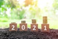 Year 2021 economy growth and recovery, increase money saving and investment concept. Wooden blocks 2021 with increasing coins. Royalty Free Stock Photo