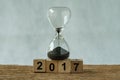 Year end 2017 business time countdown or improvement review concept as hourglass or sandglass with wooden cube block number 2017 Royalty Free Stock Photo