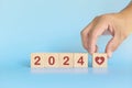 Year 2024 health goal and healthcare priority concept. Wooden blocks on blue background with icon.